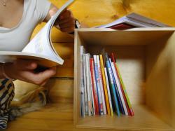 In einer Holzbox befinden sich Schulbücher aus verschiedenen Ländern, die die Besucher dazu einladen, andere Bildungsansätze kennenzulernen Box_Education